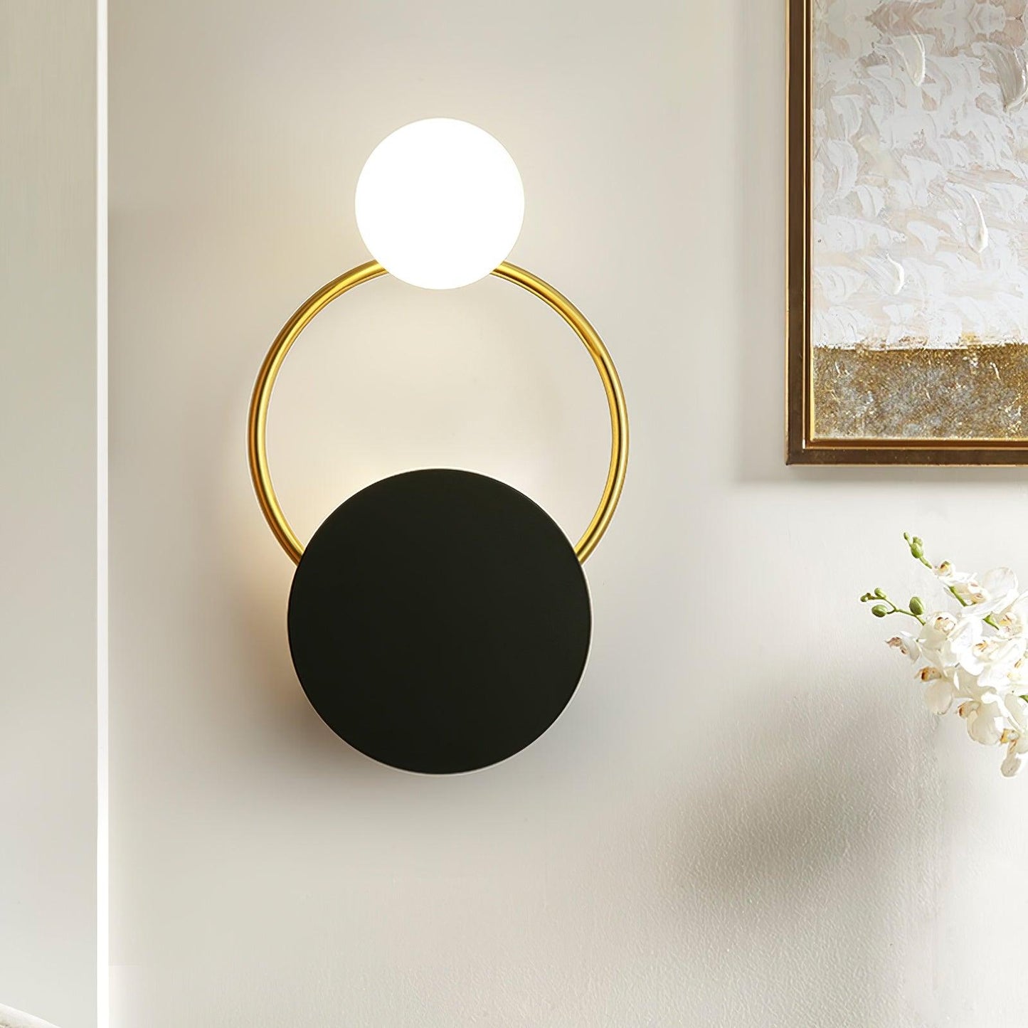 Elegant væglampe i guld og sort med unik glaskugle