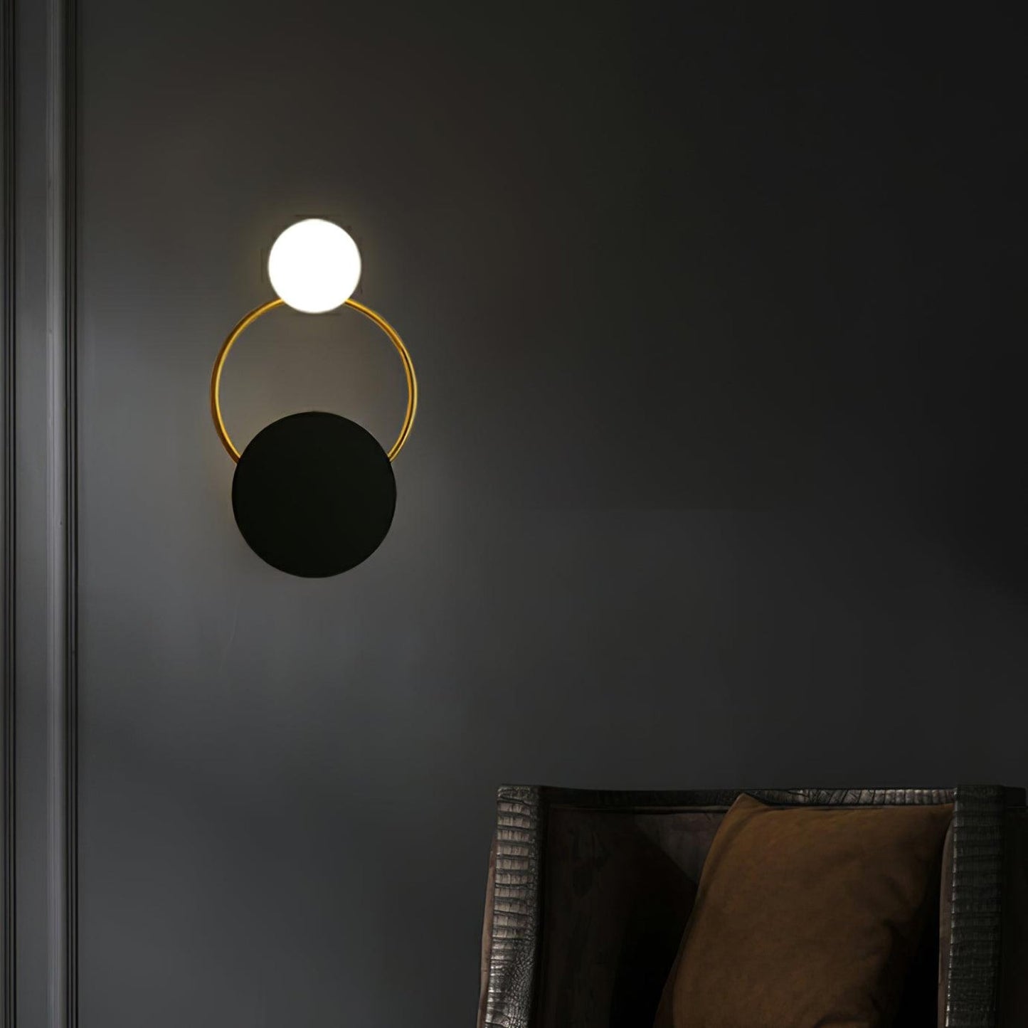 Elegant væglampe i guld og sort med unik glaskugle