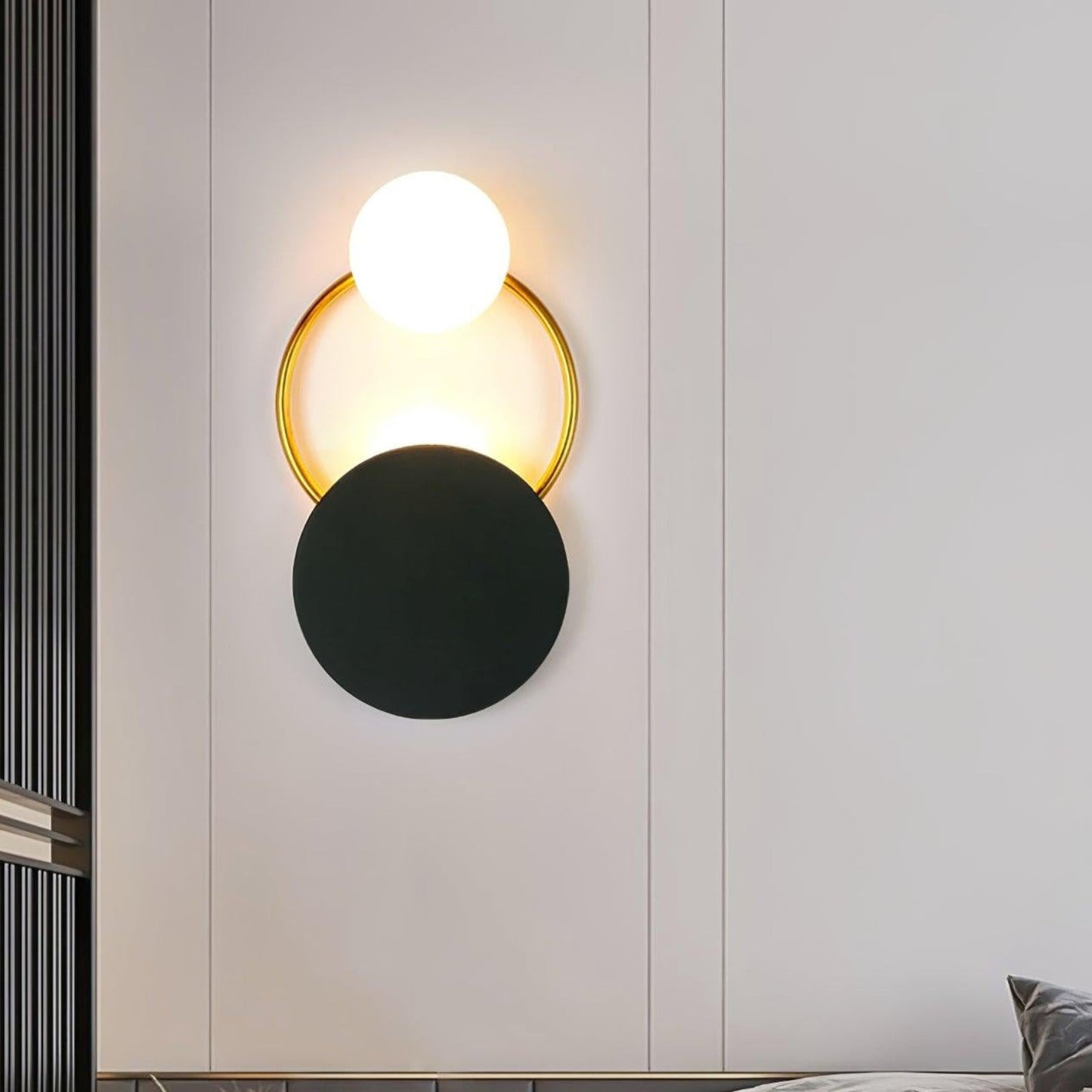 Elegant væglampe i guld og sort med unik glaskugle
