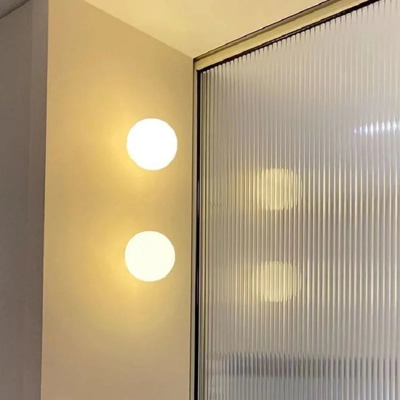 Stilren rund vägglampa i glas med mysbelysning
