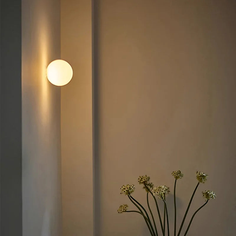 Stilren rund vägglampa i glas med mysbelysning